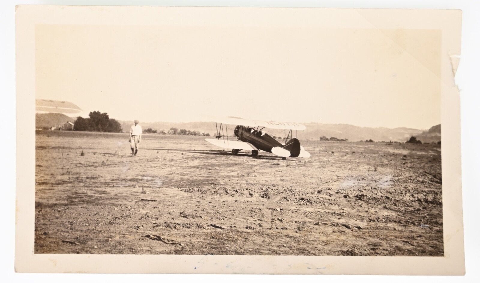 VINTAGE B&W SNAPSHOT 1932 SMALL BI-PLANE PILOT TAKING OFF IN DIRT FIELD