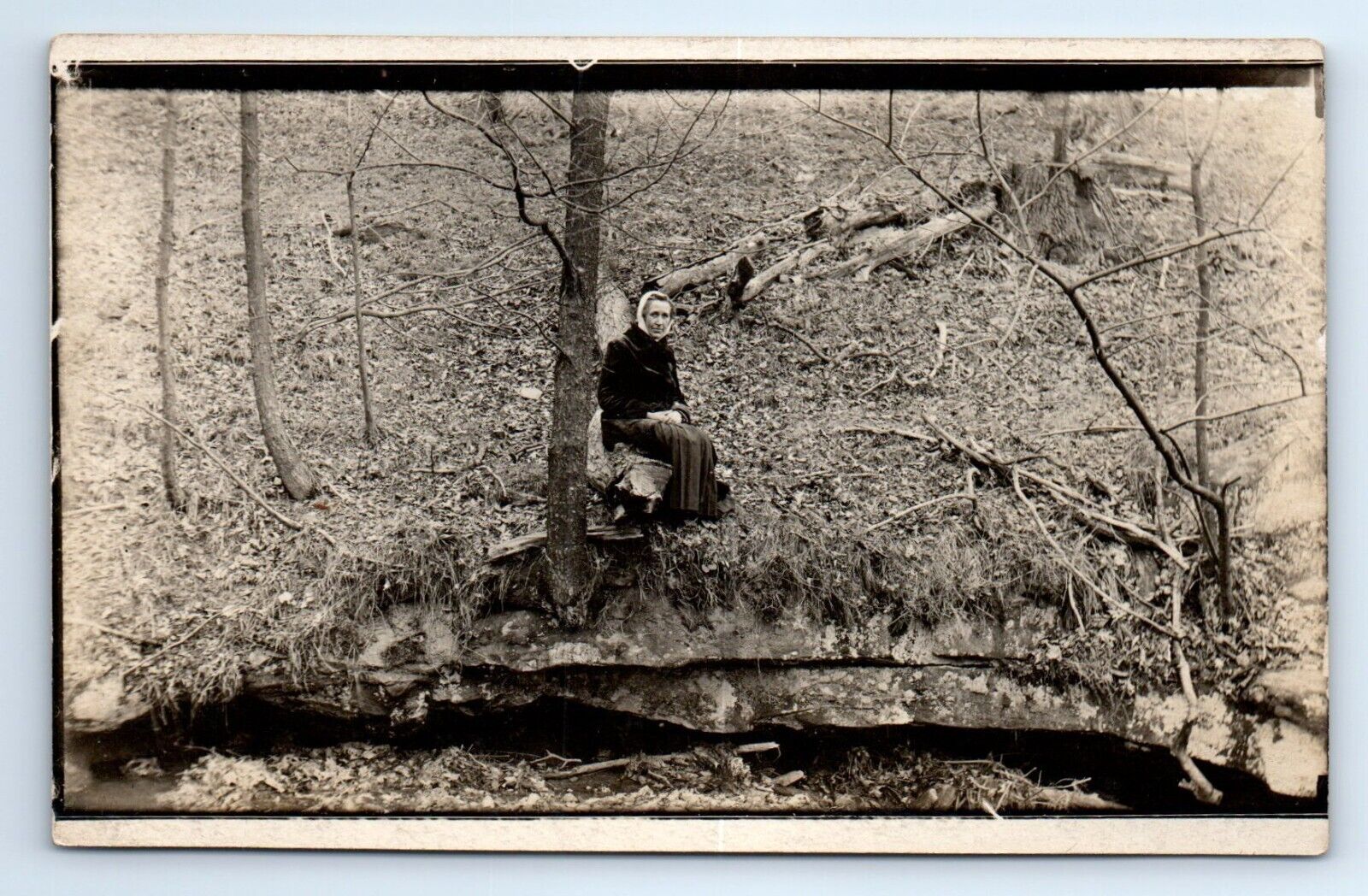 Old Woman Sitting on Log Above Creek Woods Logging RPPC Postcard c.1910