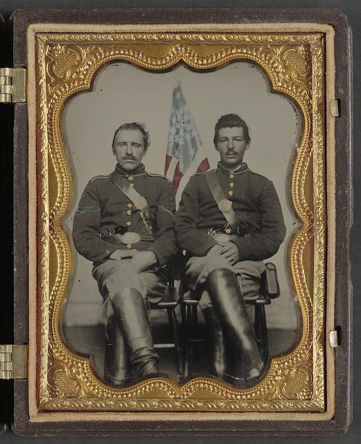 [Two unidentified soldiers in Union uniforms in front of American flag]