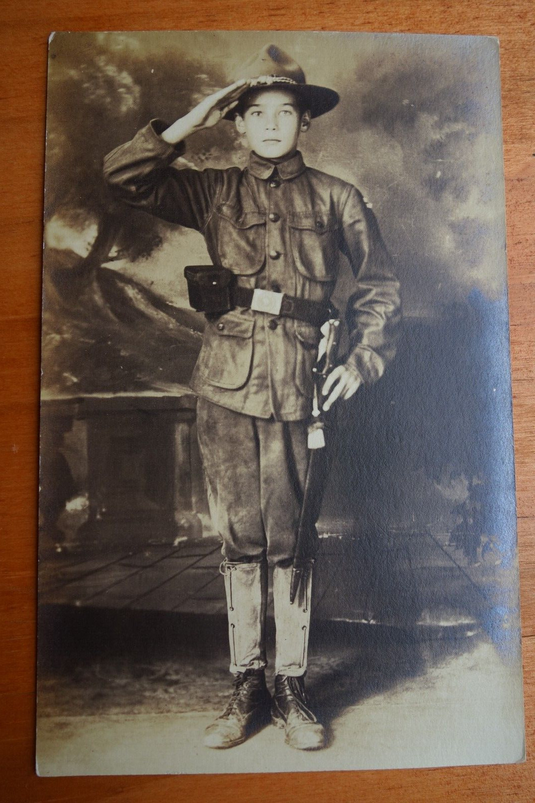 saluting young scout or trooper, in uniform real photo postcard studio rppc