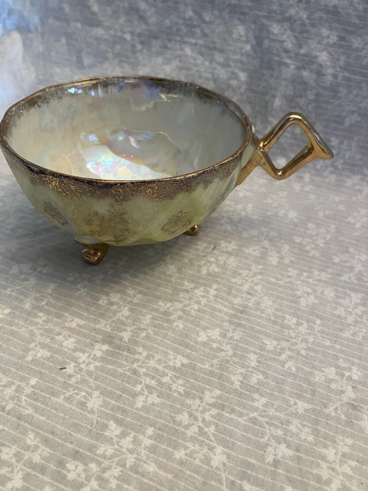 tea cup unmarked. Vintage lusterware yellow with gold. Crossed handle. 3 feet.