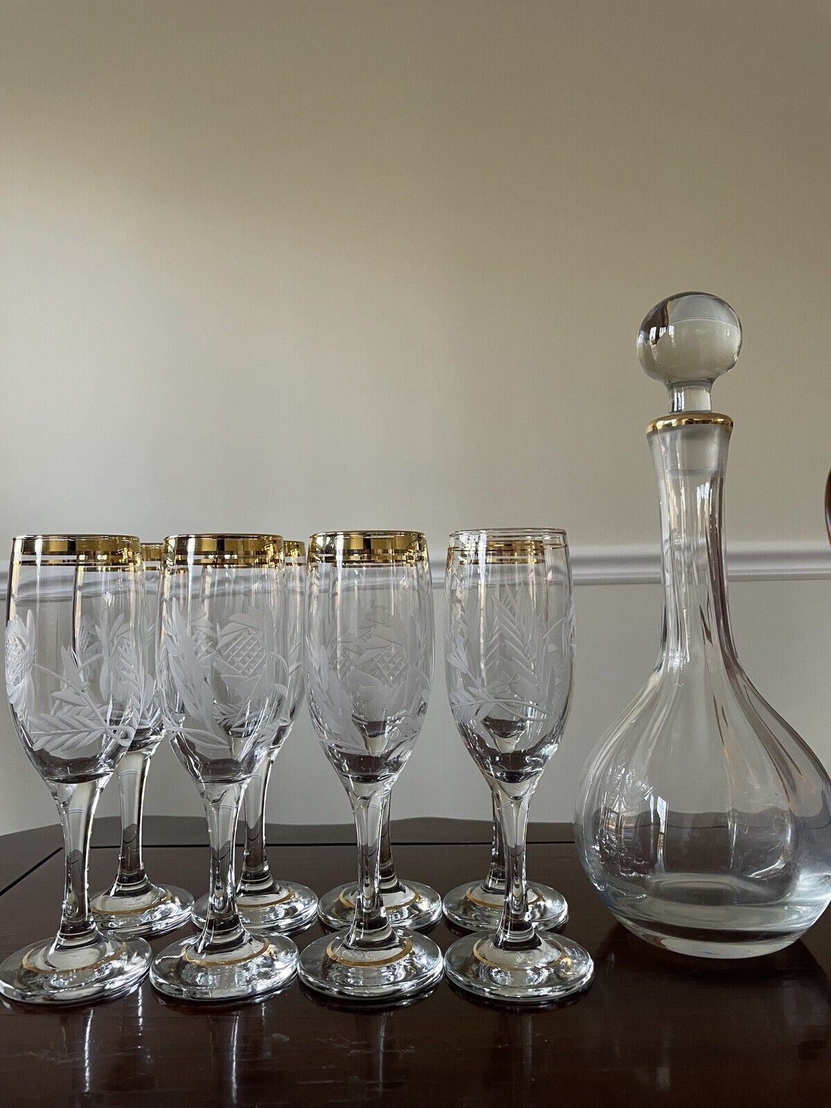 Eight (8) Gold Rimmed flutes with etched design and matching decanter