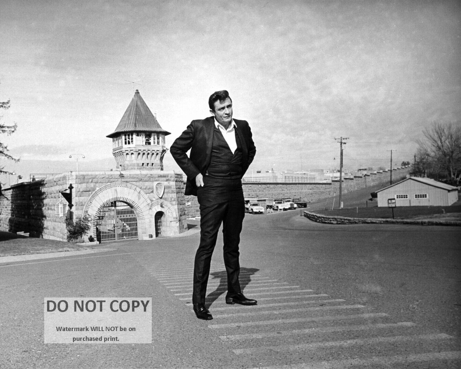 JOHNNY CASH STANDS IN FRONT OF FOLSOM STATE PRISON 8X10 PUBLICITY PHOTO (ZY-908)