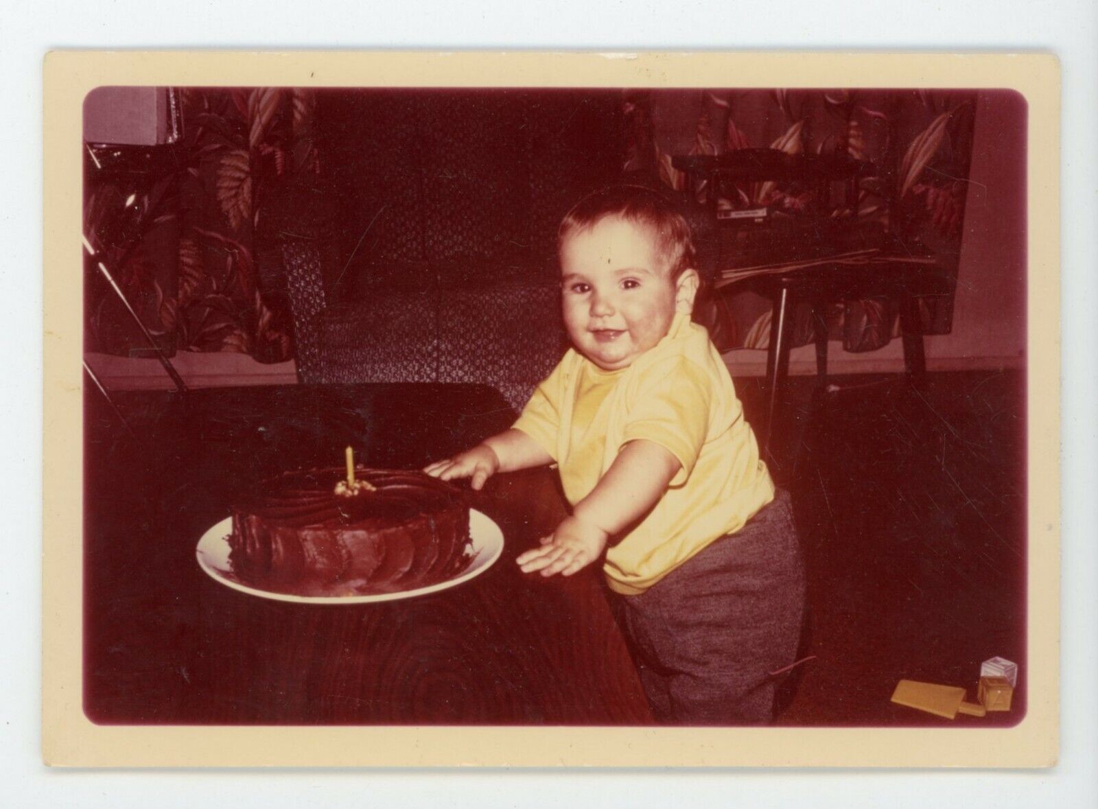 Chubby  toddler with one year birthday cake Vintage color snapshot photo
