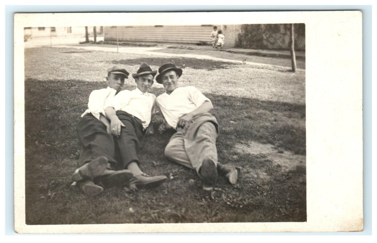 Group of Young Men Laying on Ground Domestic View Smoking RPPC Real Photo
