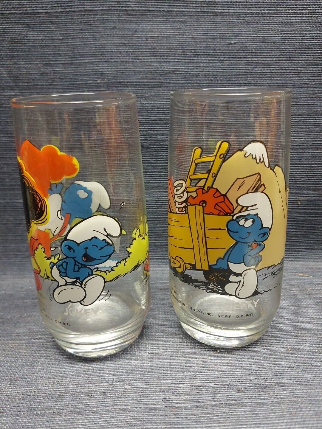 Two 1982 Smurf Collectible Glasses by Wallace Berrie & Co. Hardees Hefty & Jokey