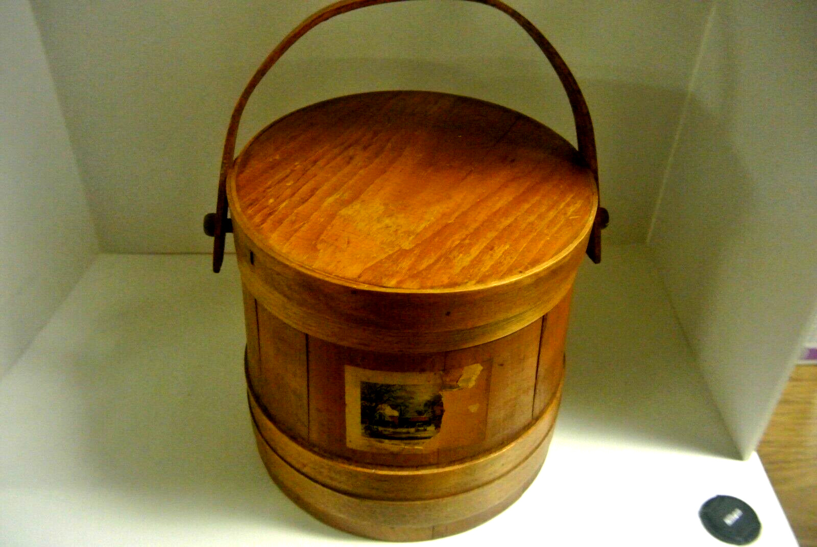 An antique wooden barrel shaped sewing basket