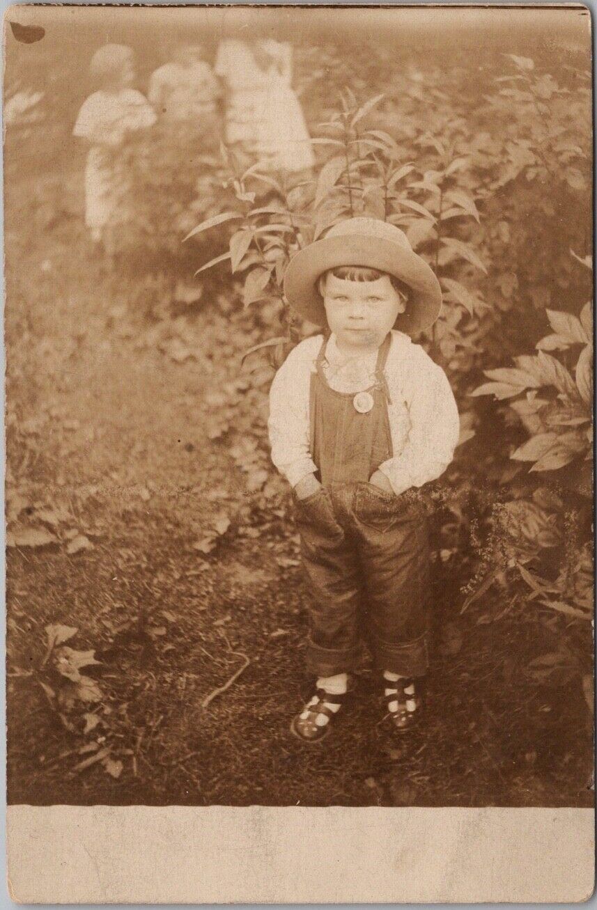 c1910s RPPC Real Photo Postcard Very Cute Child in Garden / Denim Overalls