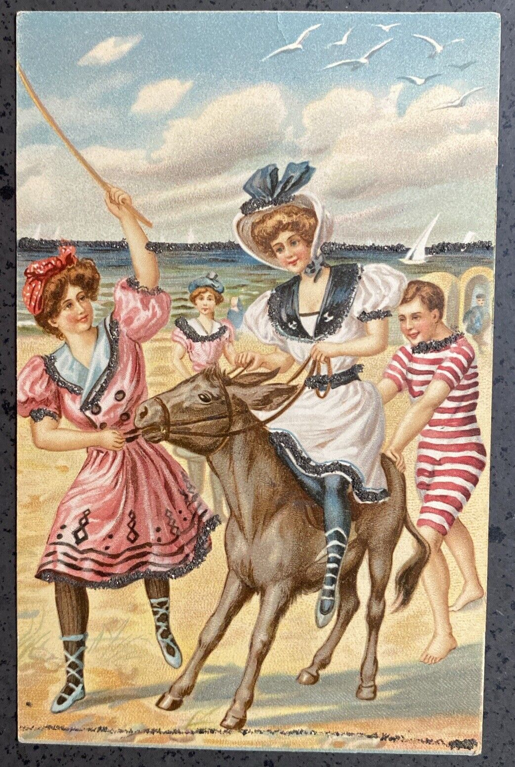 Early 1900s Bathing Beauties With Glitter  Postcard- Riding A Donkey On Beach