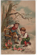 ANTIQUE EMBOSSED BIRTHDAY Postcard    BOY KNEELING, PUTTING SKATES ON YOUNG GIRL picture
