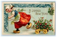 1910 New Year Girl In Dress Pulling Cart With Holly Berries Embossed Postcard picture