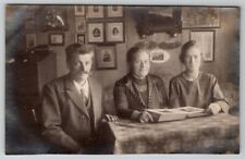 RPPC Photo of Lovely Family Looking at Photo Album Pictures on Wall Postcard D24 picture