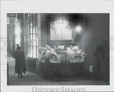 1964 Press Photo An aged woman trudges past a flower stand in England picture