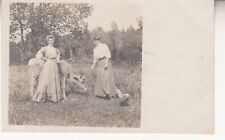 Two women with a cow, pasture. RPPC photo postcard 1900s picture