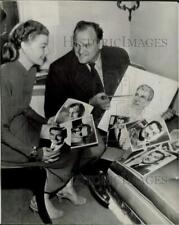 1957 Press Photo Actress Ann Sheridan Looking at Photos of Errol Flynn picture