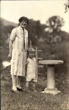 RPPC woman with odd dress and hair ~ child and bird bath ~ real photo 1924-1949 picture