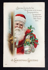 A Christmas Greeting Santa Joy & Cheer Holding Gifts at Door Postcard c1910s picture
