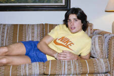Peter Barton wearing a yellow Nike t-shirt blue shorts lying on a - Old Photo picture