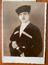 Photo portrait of a guy in a Caucasian uniform with a dagger. Vintage photo picture