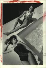 1983 Press Photo Two women lying poolside in one piece swimsuits - hcx38007 picture