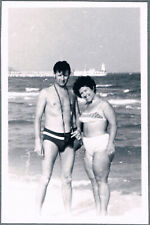 1970s Beautiful girl in swimsuit and guy in trunks on the beach   Vintage Photo picture