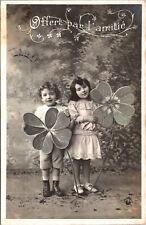 TWO ADORABLE CHILDREN HOLDING LARGE FLOWERS : OFFERED IN FRIENDSHIP : RPPC picture