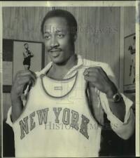 1975 Press Photo Basketball player George McGinnis holds up New York jersey picture