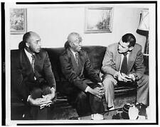 Two unidentified African American men seated on a sofa, talking to a young ma... picture