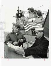 1987 Press Photo Eric Morris looks over Galveston guide aboard USS Farragut picture