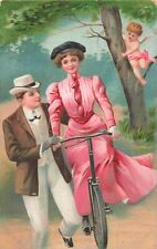 FINELY DRESSED COUPLE-CUPID WATCHES ROMANTIC BICYCLE LESSON~1910s POSTCARD picture