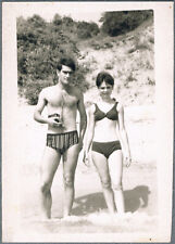 1970s Beautiful girl in swimsuit and guy in trunks on the beach   Vintage Photo picture