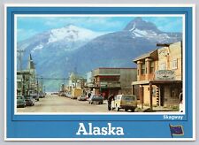Skagway Alaska, Trail of 98 Street View Old Cars Shops Mountains, VTG Postcard picture