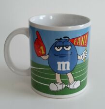 M&M Coffee Mug Cup by Galerie Mars with Green Cheerleader and Blue #1 Fan picture